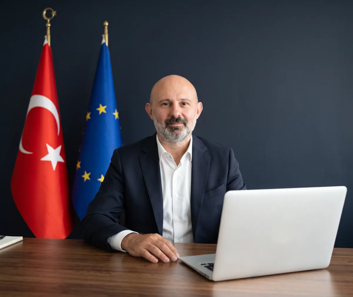 Ata Vize danışmanı ofiste, Türk ve AB bayrakları önünde